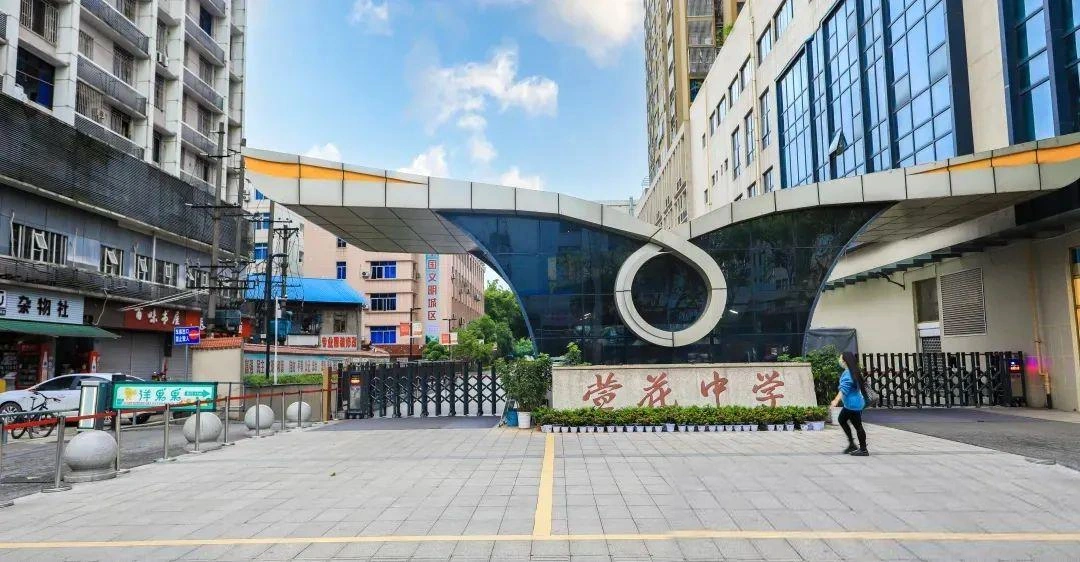 萱花中学西门实拍，保留两侧楼房、商铺、道路和入口原貌
